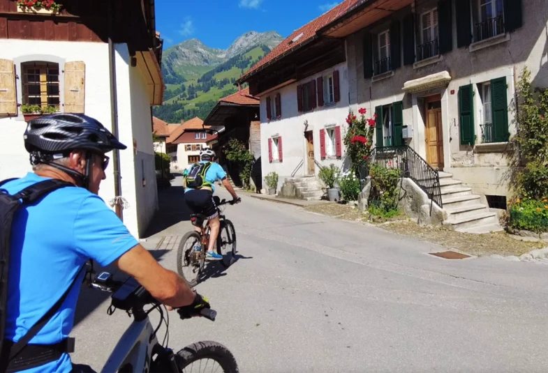 Ältere Männer fahren mit dem E-Bike durch ein Bergdorf